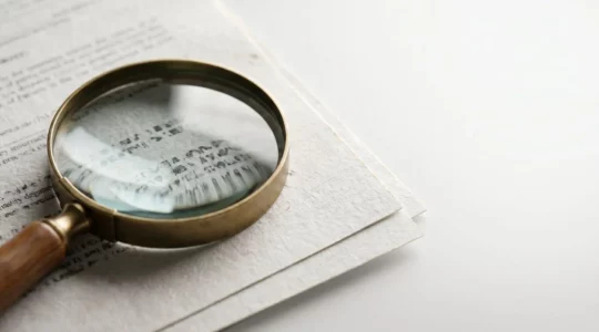 Gros plan sur des documents de mutuelle santé avec une loupe révélant des détails importants